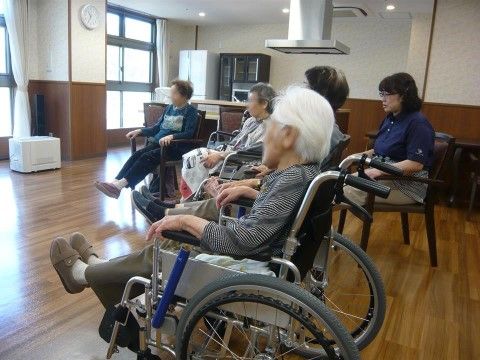 広いフローリングの部屋に並んだ車椅子に乗った高齢者様