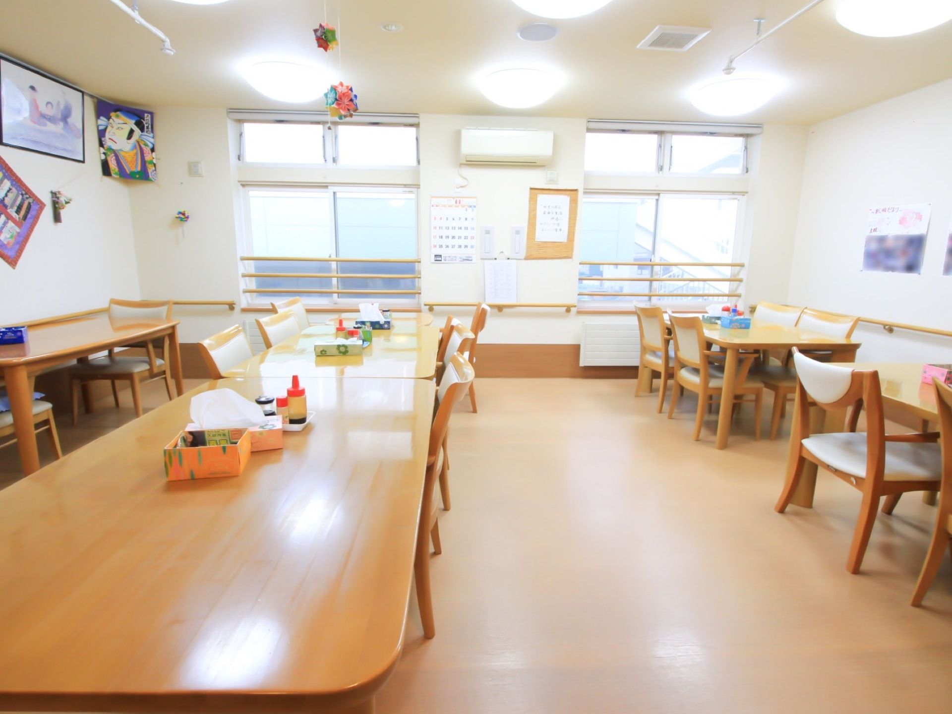 テーブルが多く設置されている。照明が多く、明るい。窓は大きく、手前には柵が付けられているため、安心である。