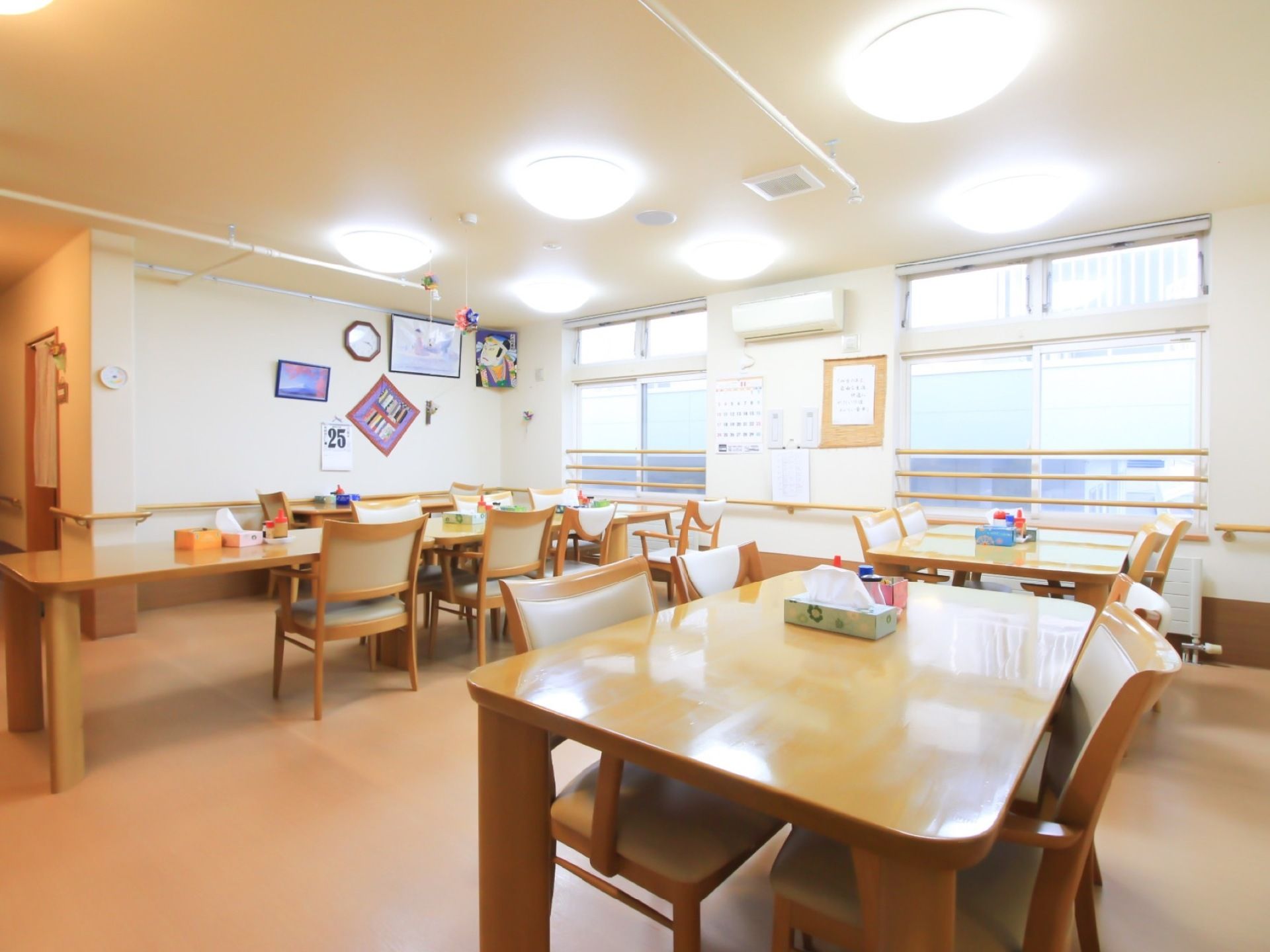 広い食堂である。テーブルの間隔は広く取られている。壁には、時計、カレンダーなどが飾られている。照明が多くつけられている。