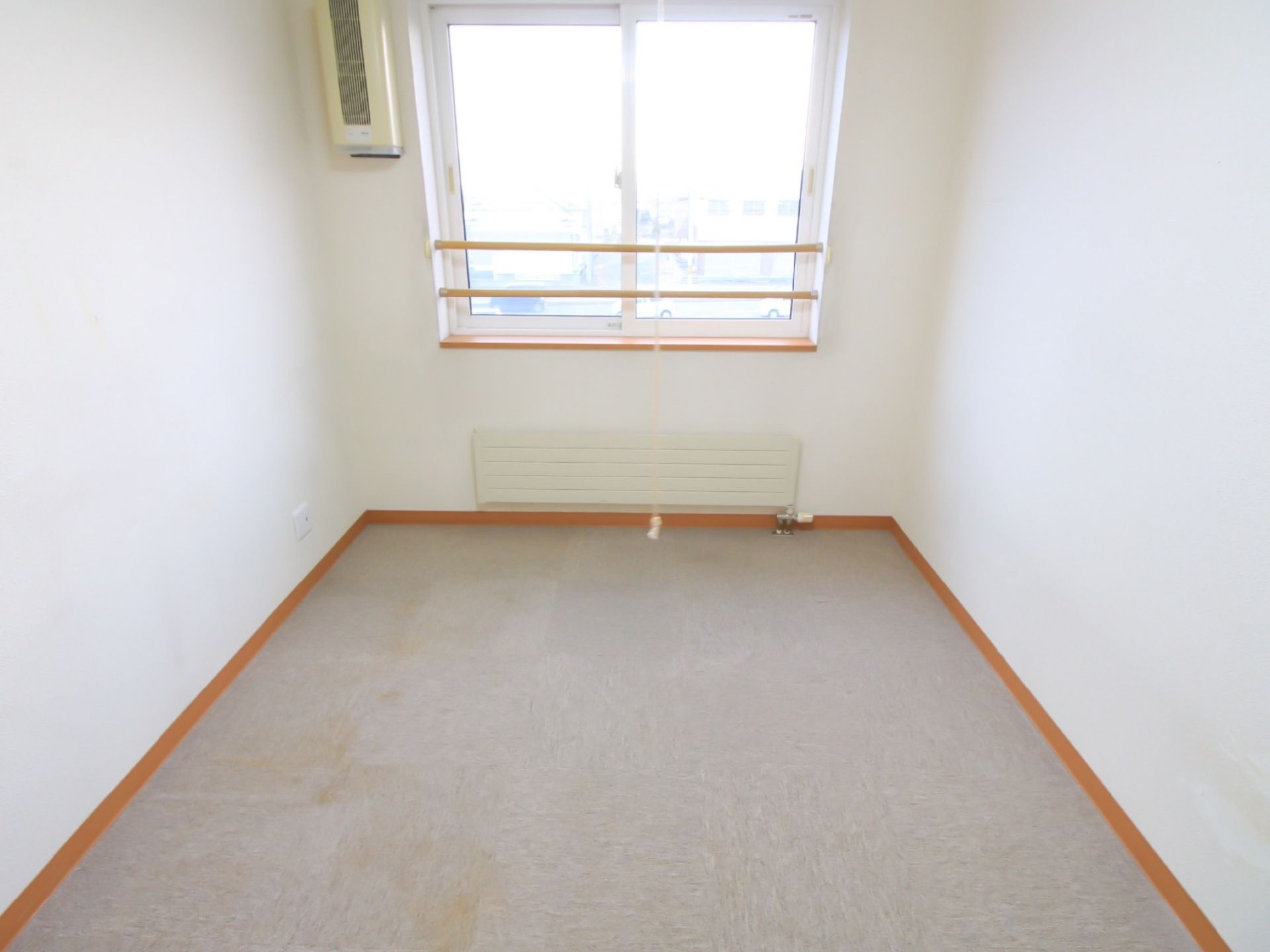 空調設備が設置されている。窓が大きく、部屋全体に光が差し込んでいる。床はフロアカーペット仕様となっている。