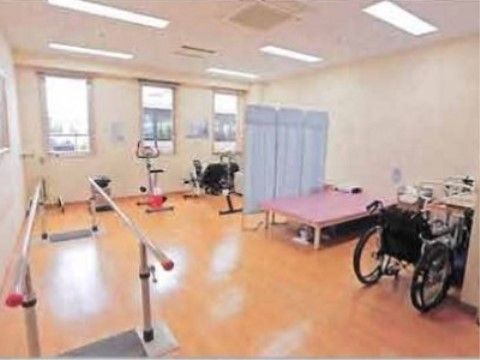 リハビリテーションのためのさまざまな器具が設置されている。車椅子を利用している方が実際に機能訓練室を利用している。