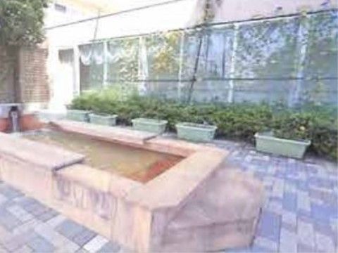 木や草花などの自然に囲まれた心落ち着く足湯である。多くの人が団らんできる十分なスペースが確保されている。