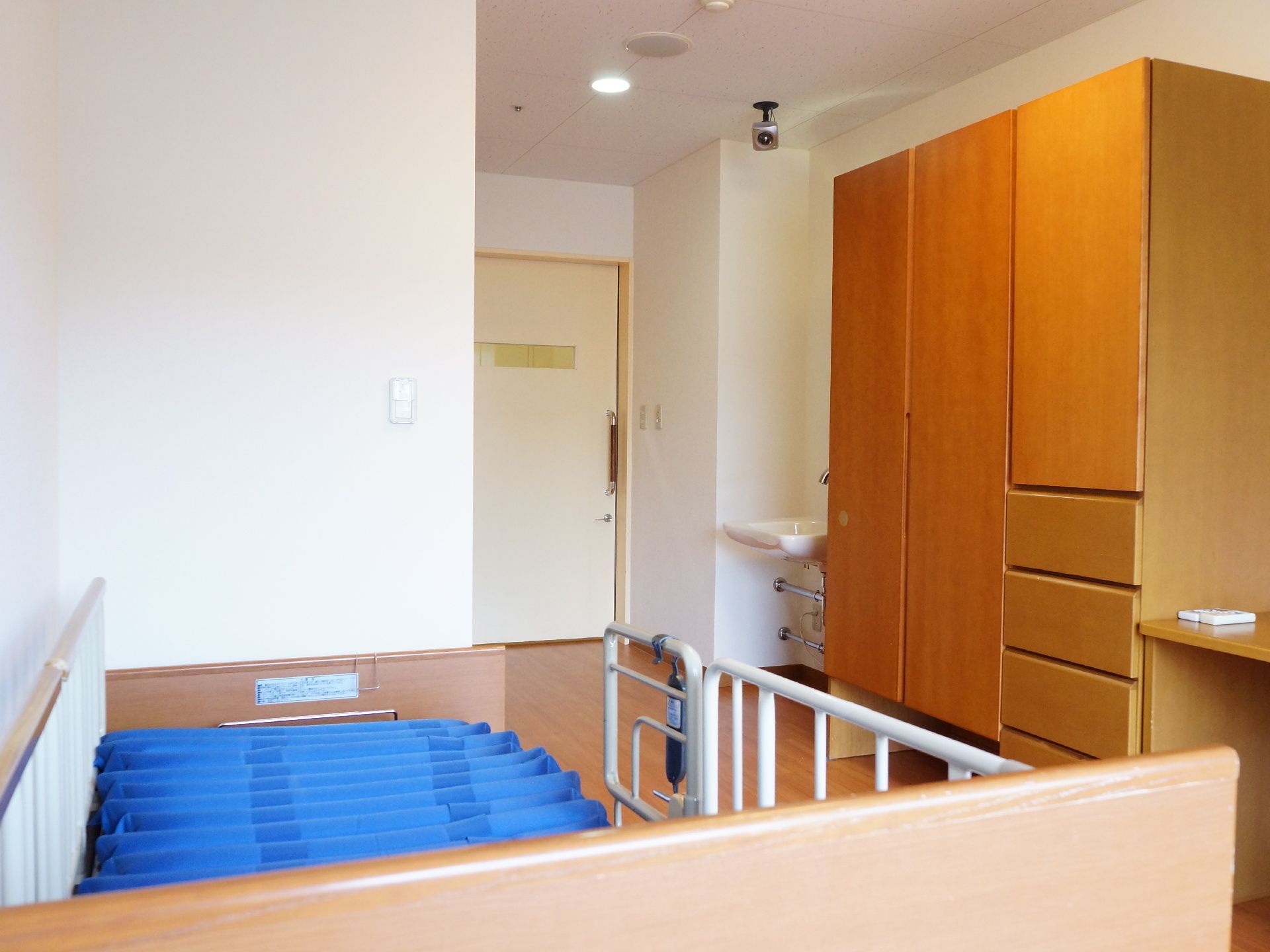 室内には広々としたテーブルが用意されている。また天井には入居者を見守るために、監視カメラを設置している。