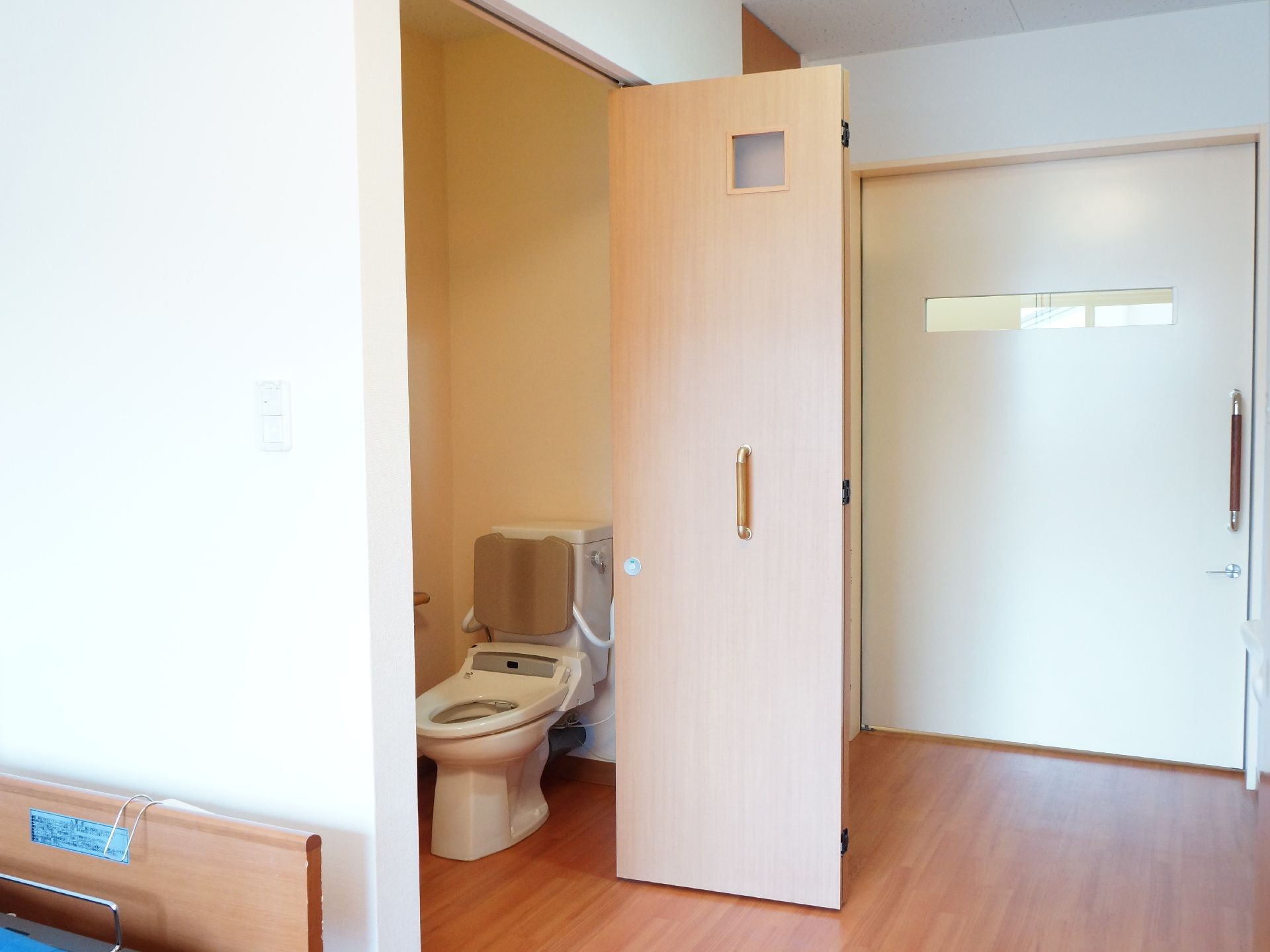 居室の入り口にはスライディングドアを設置している。また室内のトイレも高齢者に配慮して、便利な折れ戸のドアを採用している。