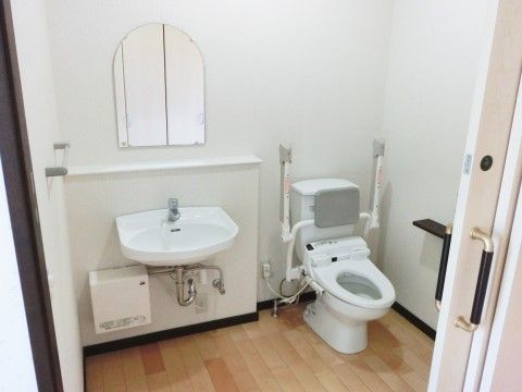 白を基調としているので、明るい印象で清潔感がある。洗面台、トイレ共に手入れが行き届いている。便器には手すりや背もたれが付いている。