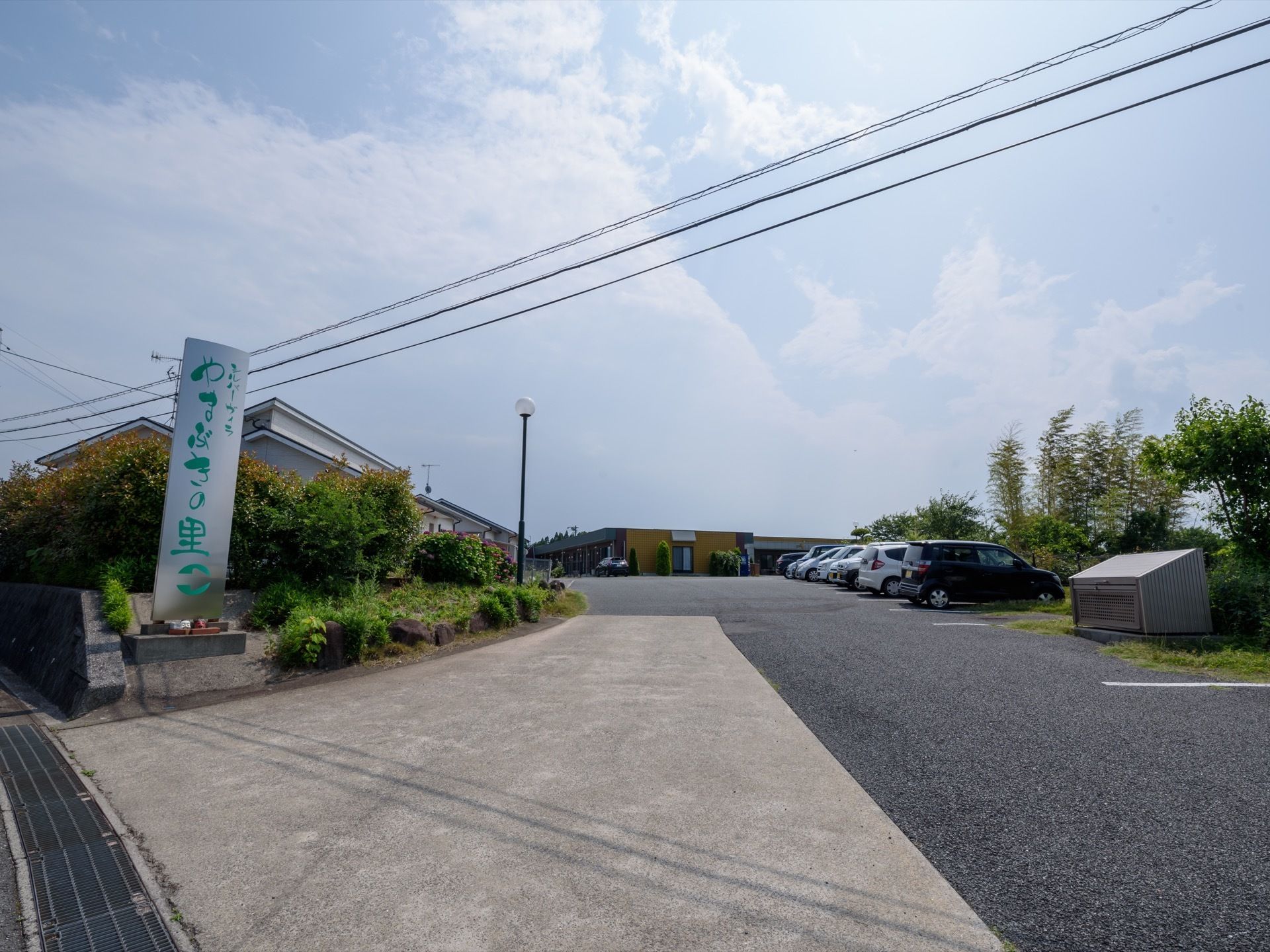 施設の周りは緑が多く、自然に囲まれた環境である。敷地内の広い車の駐車スペースには、5台以上もの車がある。