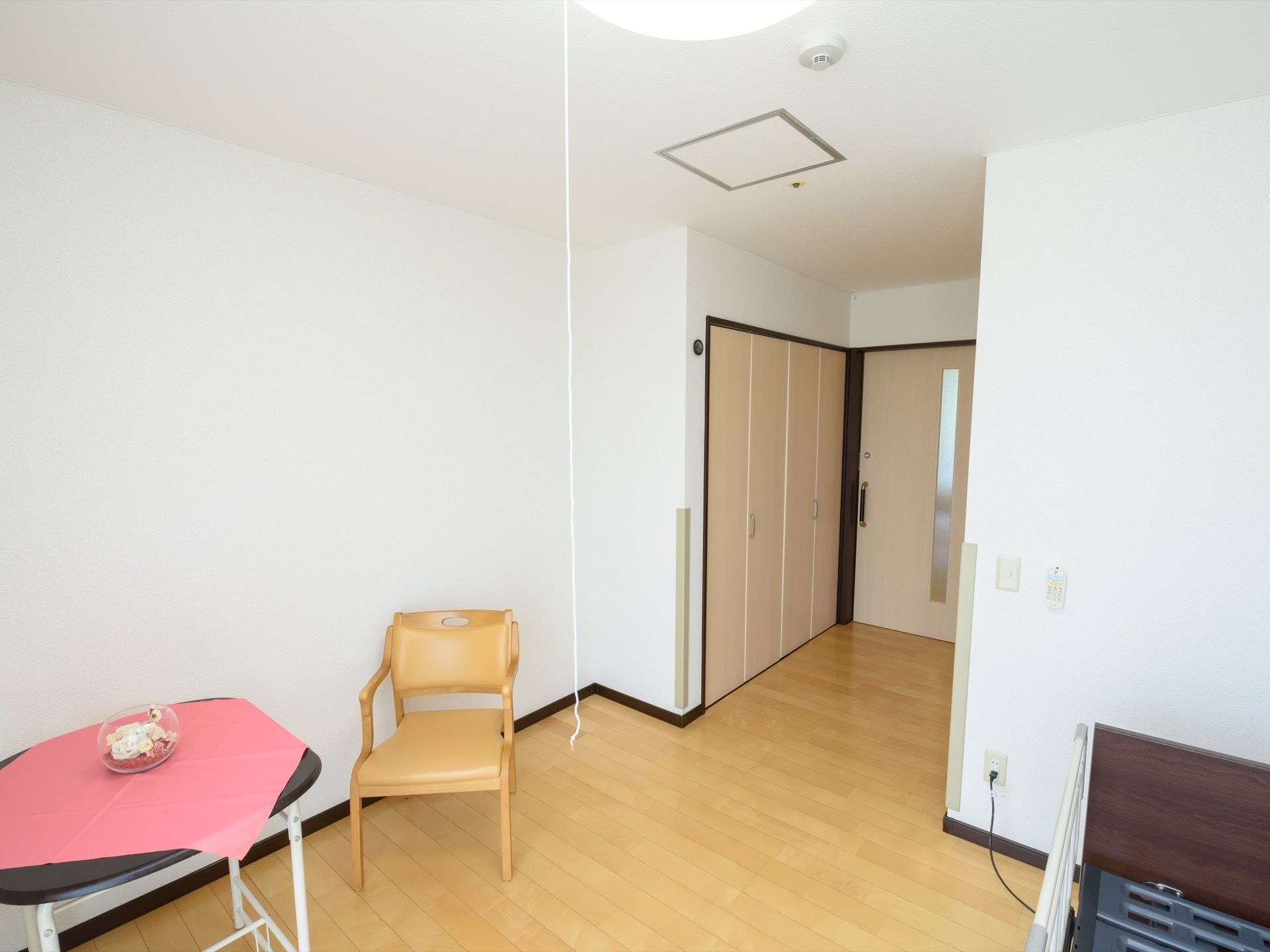 居室を入ってすぐの場所にはクローゼットがある。テーブルの上にはテーブルクロスと花が飾られており、華やかになっている。