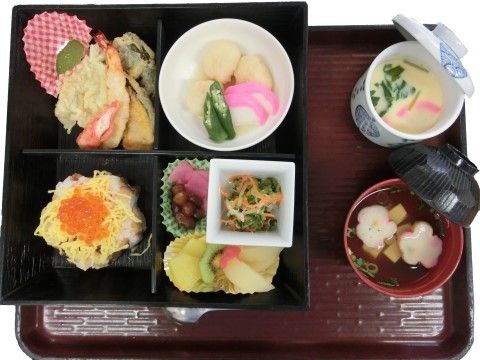 お重を区切って様々なおかずの並べられた、彩りにもこだわった施設のお食事