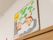 天井付近の白い壁に、ちぎり絵で作られた色鮮やかな手作りの看板が掛けられている。浴室への案内板となっている。