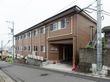 施設は2階建てで右側に外階段が付いている。1階の玄関近くの外壁に施設名が書かれていて、建物の前は緩やかな坂道になっている。