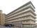 6階建ての茶系の建物で、多くの入居者様が一緒に生活をされている。各部屋には大きな窓とベランダがある。