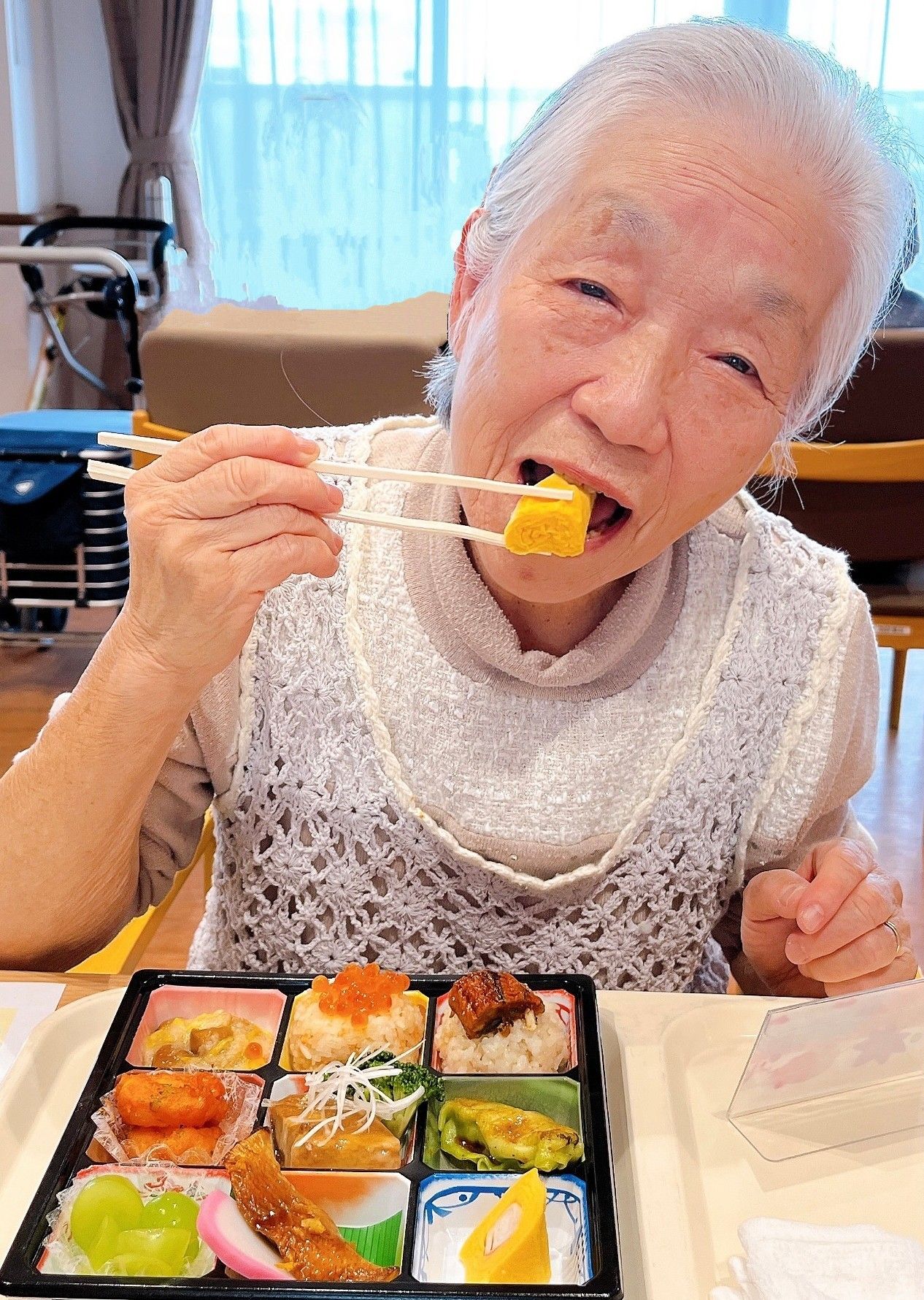 数人の入居者様がダイニングテーブルでくつろぐ、明るい食堂
