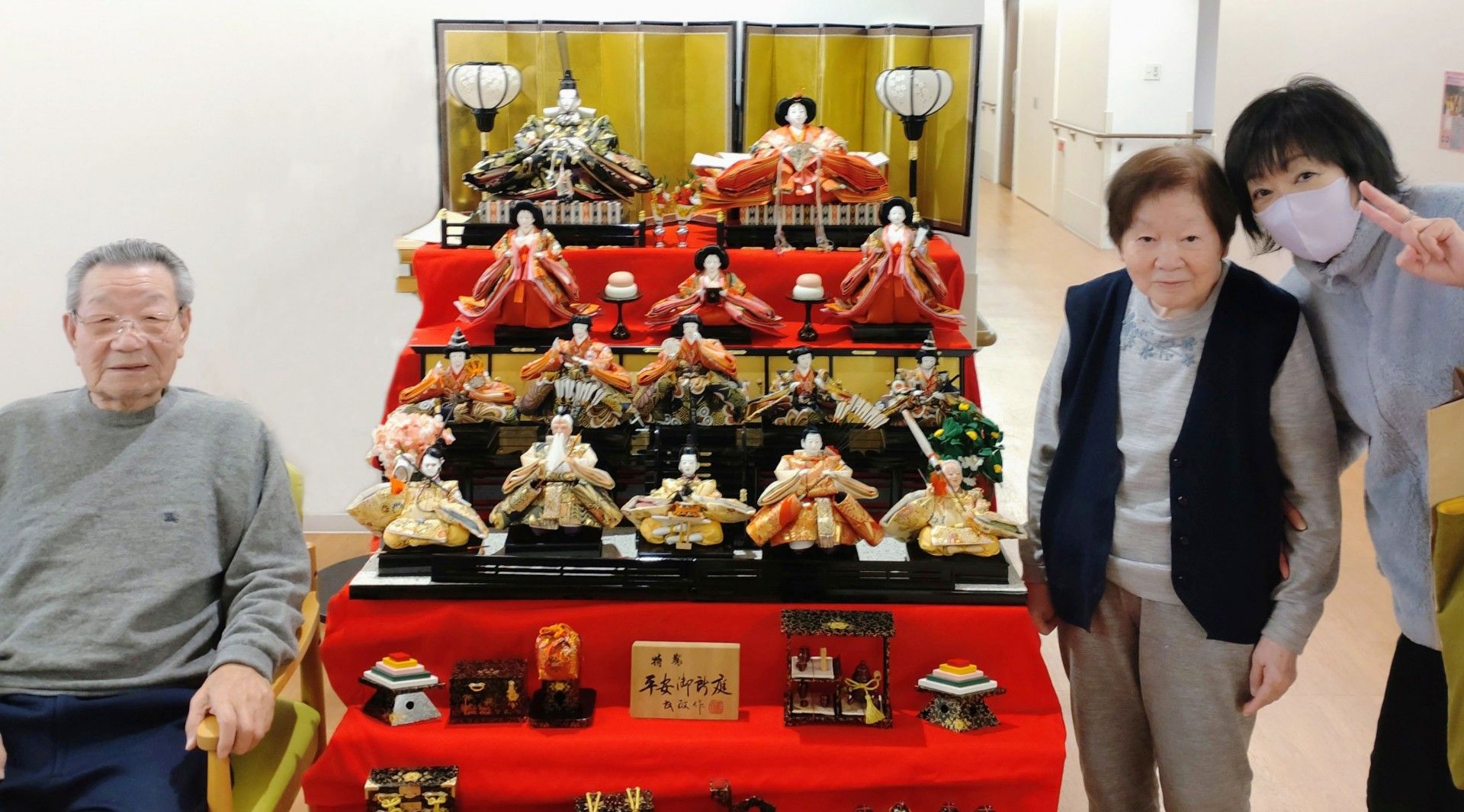 立派な雛人形が飾られている横で、記念撮影する数人の入居者様