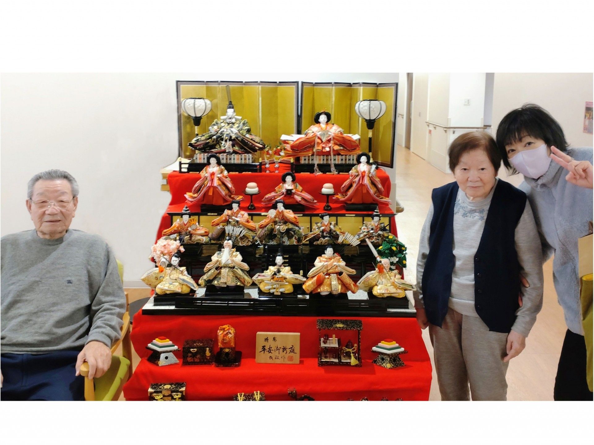 立派な雛人形が飾られている横で、記念撮影する数人の入居者様