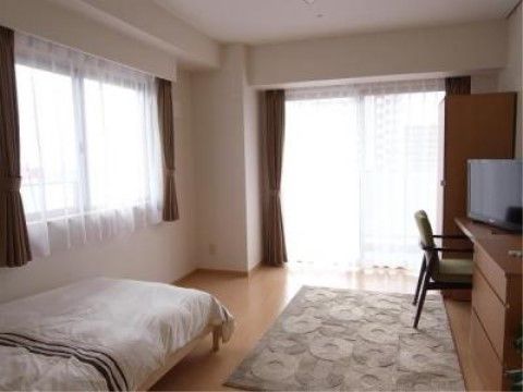 掃き出し窓と腰高窓がある、収納やベッドなどが設置された居室