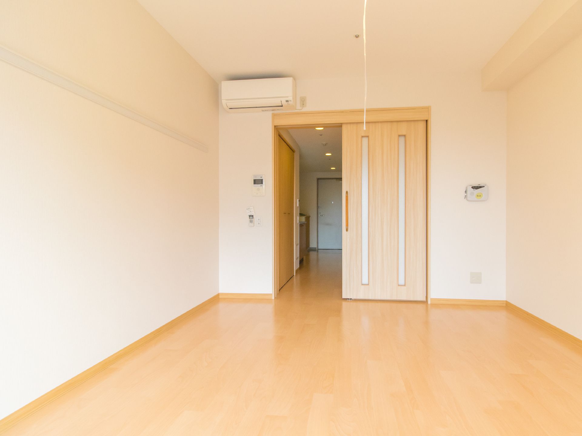 エアコンが設置された居室は、快適に過ごすことができる。部屋の入り口は、明るいベージュ色の引き戸になっていて、安全に開閉できる。
