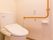 トイレは温水洗浄便座になっていて、便器の脇にボタンが付いている。手すりがついているので安全に利用できる。