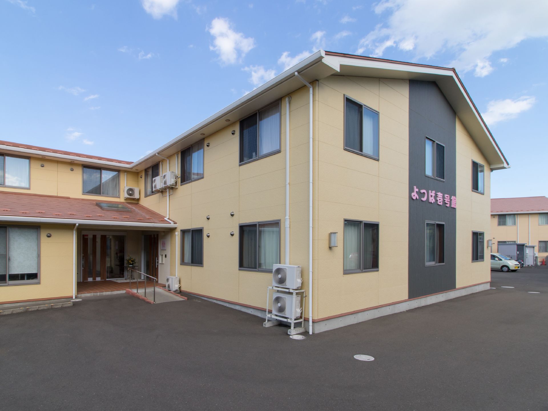 施設は壁のほとんどが黄色で2階建てである。玄関の前はとても広いスペースがあり、敷地内には駐車場も完備されている。