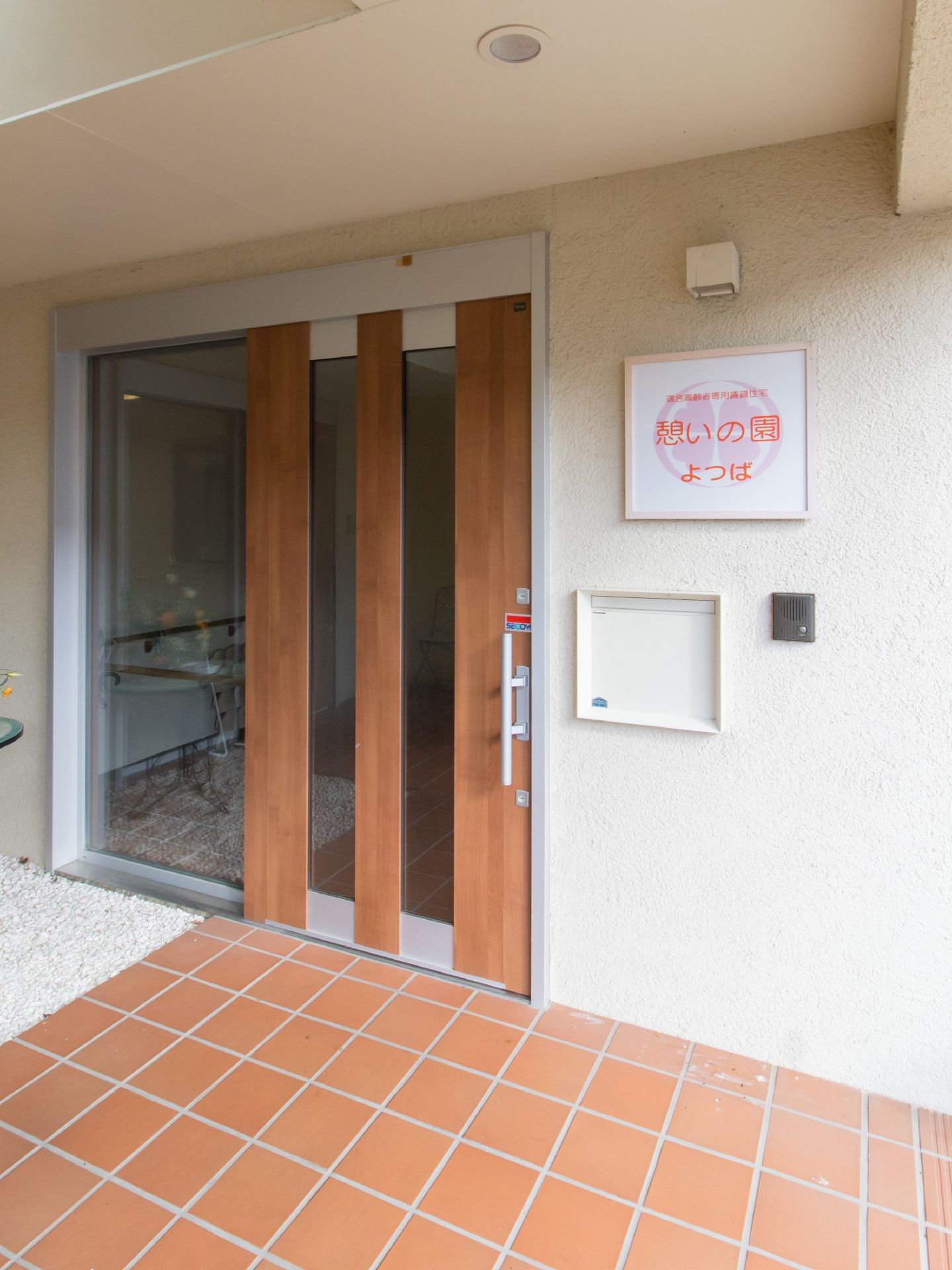 玄関のドアはスライド式である。ガラスの部分もあり、開放感がある。段差はなく、車いすの方も安心して出入りできる。