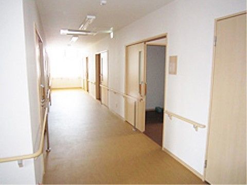 車椅子でも通れる十分な広さがあり、両側の壁に手すりが設置されている通路