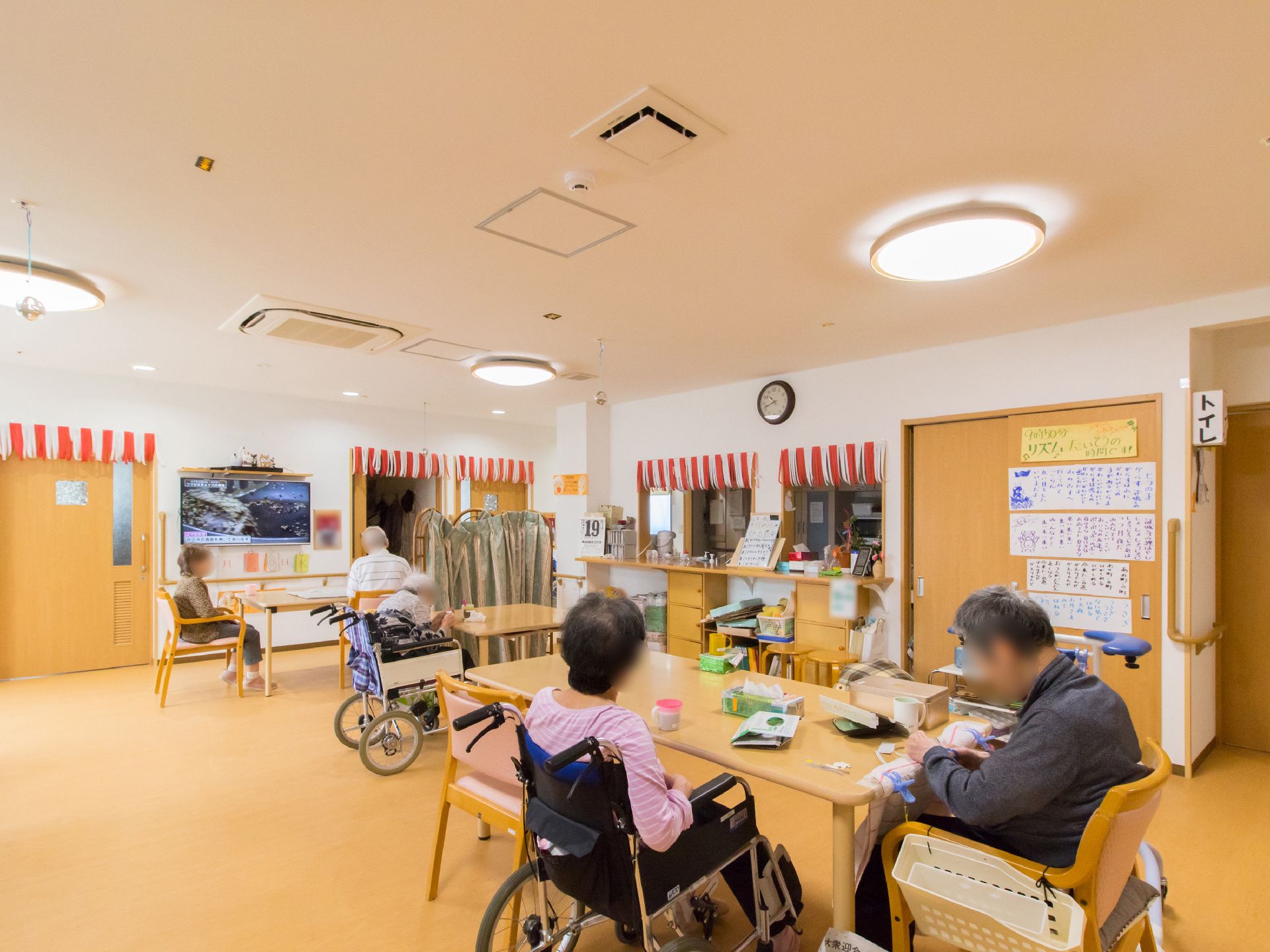 椅子や車椅子に座った入居者様が自由にくつろいでいる食堂