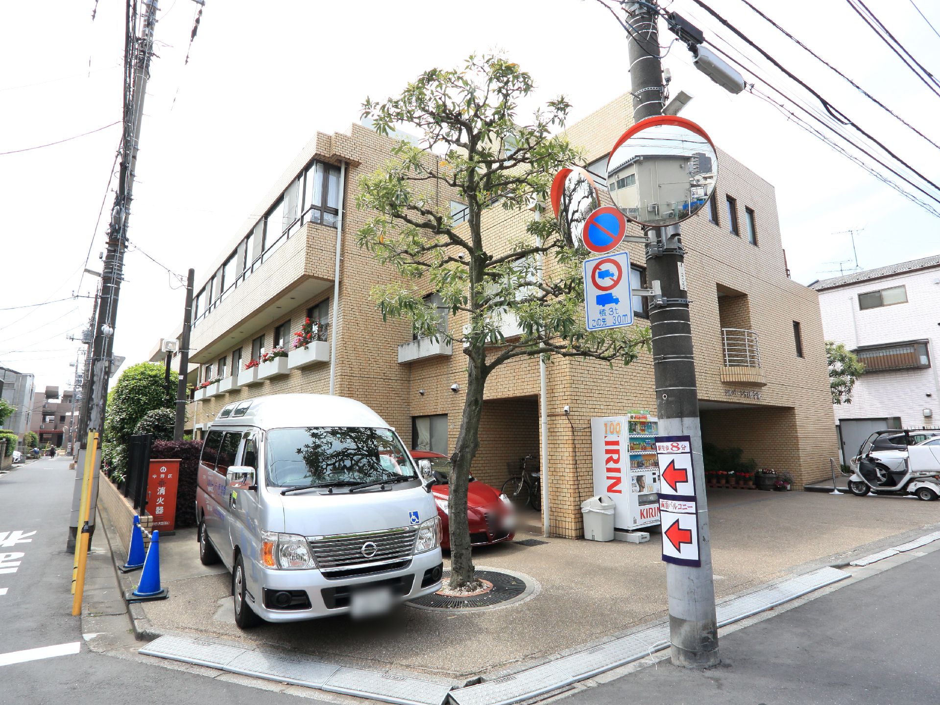 施設の建物前に車が停められている様子。
