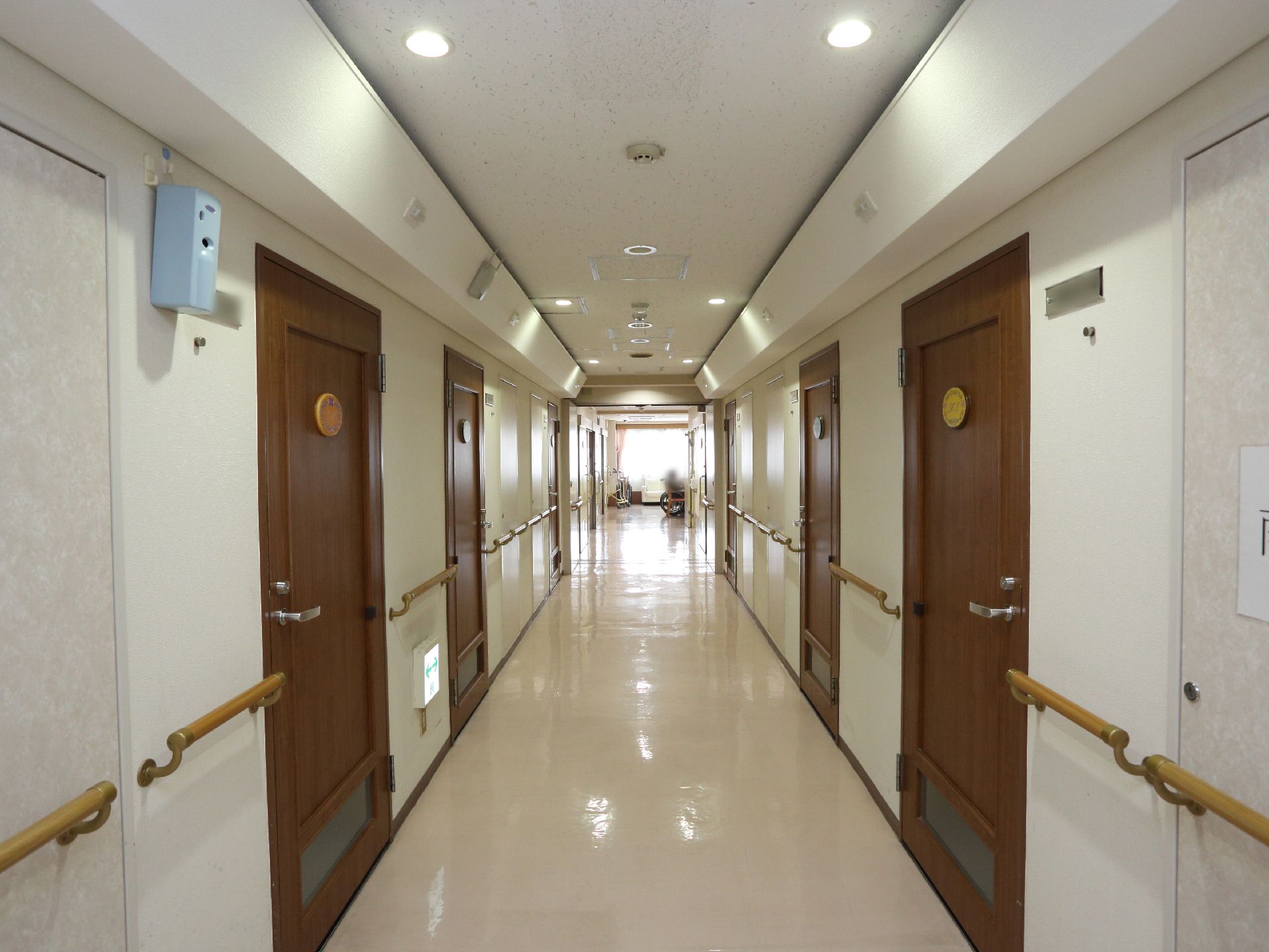 壁に手すりの設置された長くつづく廊下。