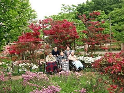 つつじの花に囲まれて記念写真を撮るご入居者様の様子。