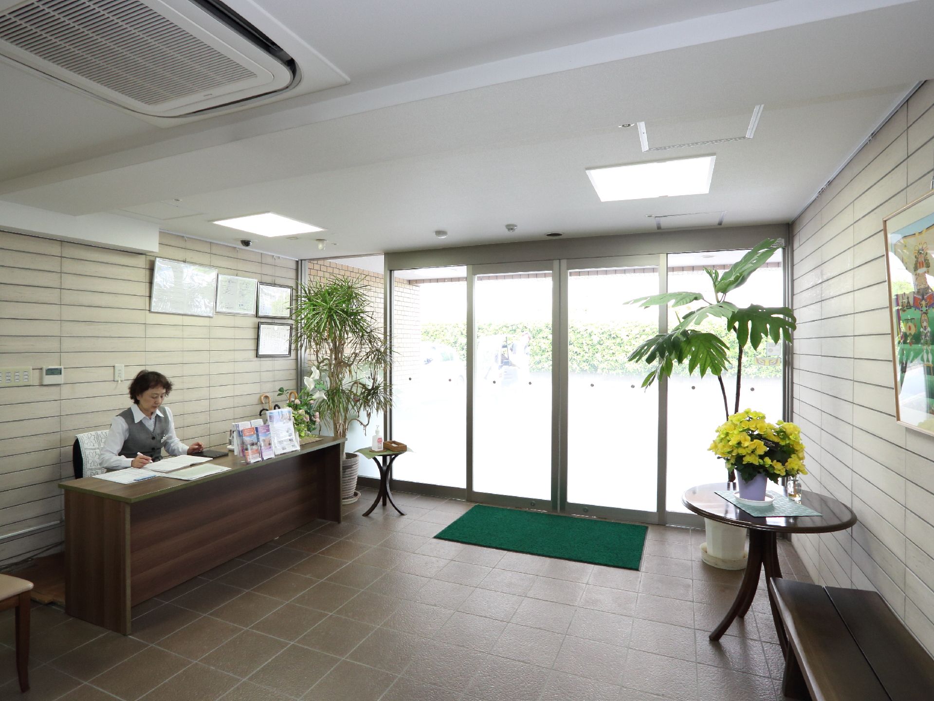 花が飾られているエントラス。受付を設けスタッフを配置している。