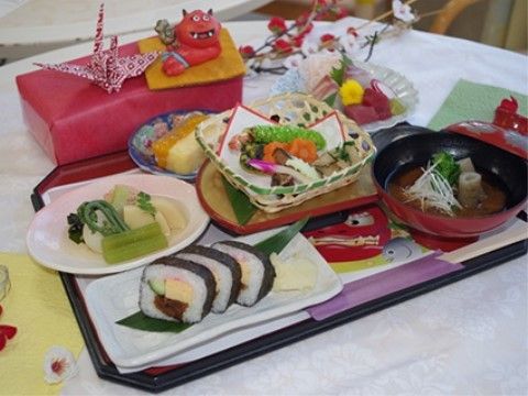 赤鬼や折り鶴が飾られた刺身や巻きずしの和食セット
