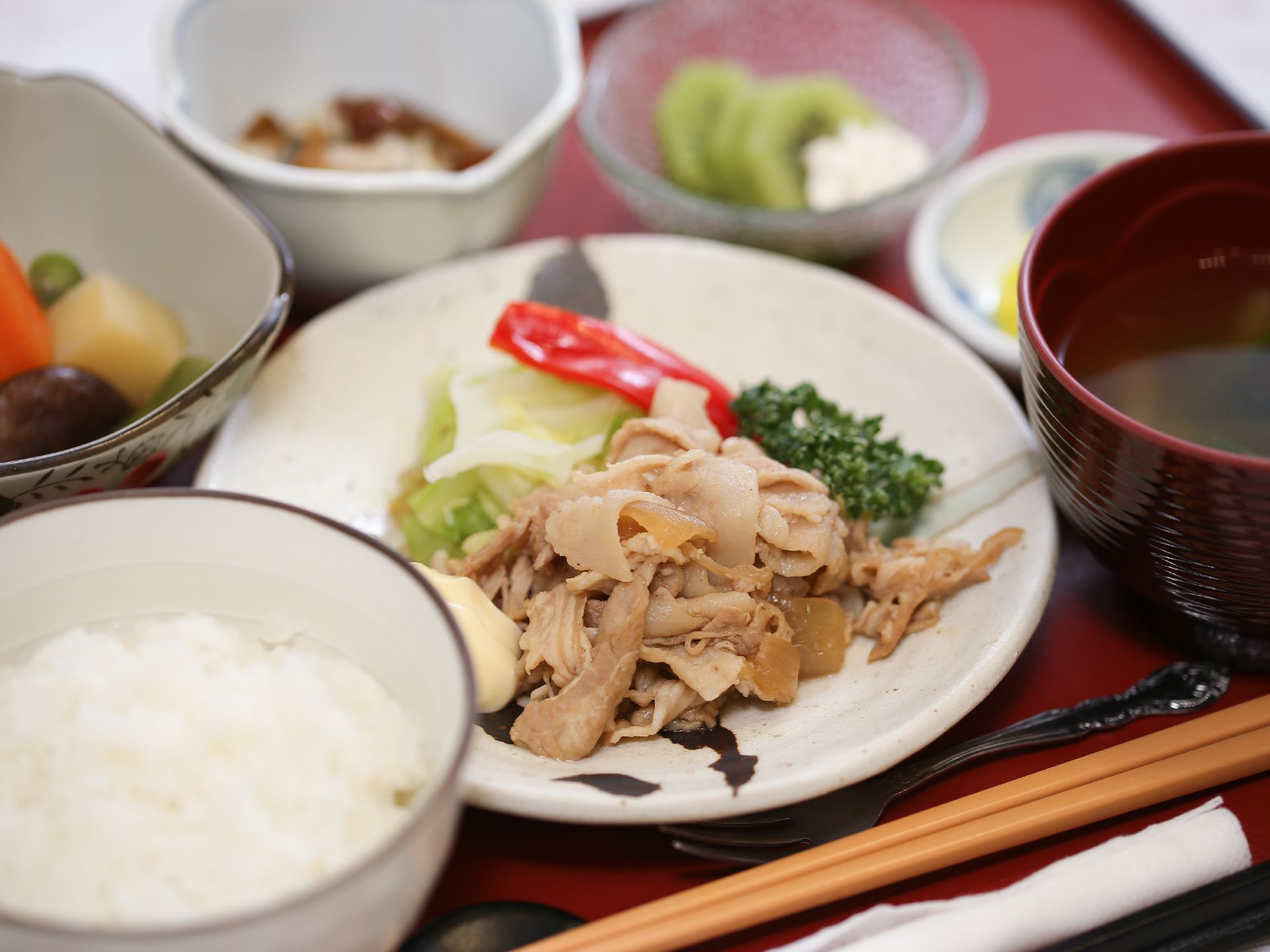 メインディッシュとして、野菜と肉の炒め物。野菜の色は鮮やかに残っている。陶器の皿に盛りつけられている。
