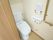 トイレが居室に備わっている。温水洗浄便座やＬ型手すりが設置されている。呼び出しボタンが壁に備え付けられている。