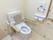 多目的トイレの洋式便器には、背もたれ付きアームレストが装備されている。壁には、Ｌ型手すりや呼び出しボタンが設置されている。