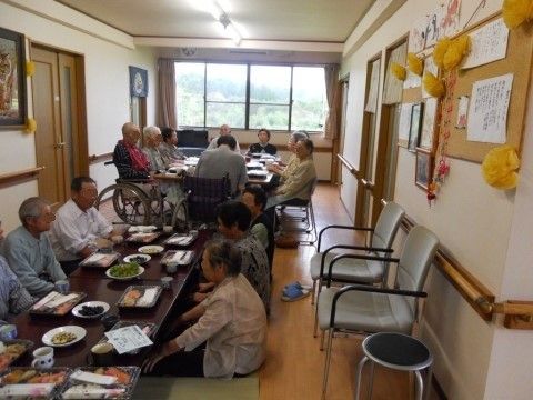 食堂で食事をしている様子。椅子に座っている入居者様と座布団を敷いている入居者様でテーブルが分かれている。