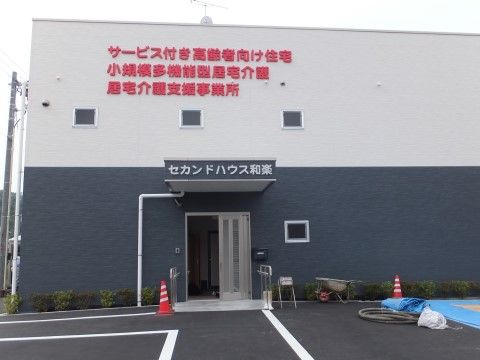 建物は2階建てで、周囲には植え込みがある。２階部分の壁には施設について表記されており、屋根の上にテレビアンテナが設置されている。