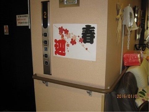 黒い扉のエレベーターが設置されている。壁には手すりが取り付けられており、周辺にはソファーや電話が用意されている。