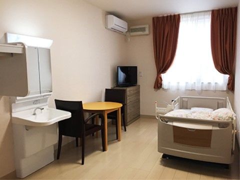 窓やエアコン、洗面台が完備されている居室には、テーブルセットが置かれ、お一人の時間も快適にくつろいでいただける。