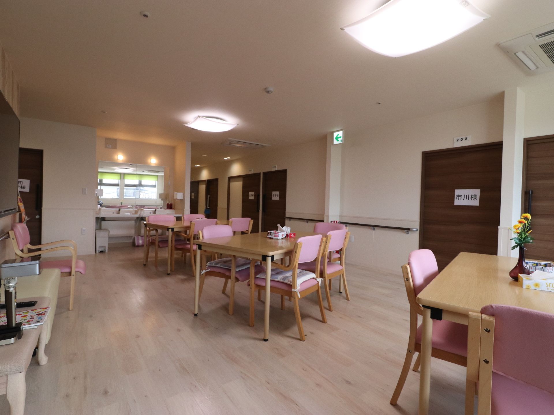 リビングルームの天井には埋込み型のエアコンと、照明器具を設置している。また非常口への誘導灯も取り付けられている。