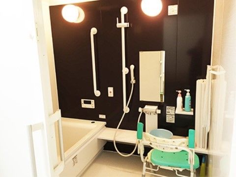 壁に手すり、洗い場にシャワーチェアが設置された個浴室