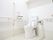 白が基調の明るいトイレには手すりがあり、可動式のものも設置されている。温水洗浄便座で、壁にボタンが取り付けられている。