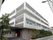 建物は4階建てになっている。敷地内にはたくさんの木々が植えてある。薄いグレーやブラウンを基調とした外壁になっている。