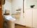 洋式トイレが設置されており、温水洗浄便座になっている。ボタンが壁に取り付けられているので押しやすい。物入があり、お花が飾られている。