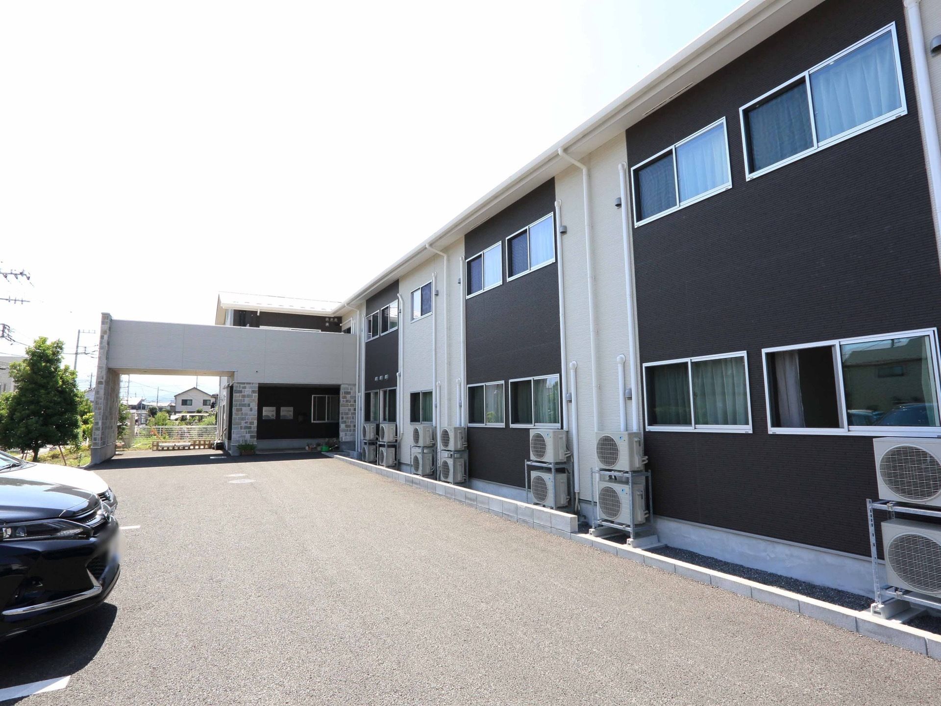 黒い壁面と白い壁とが交互に連なった外観をしている。屋外に並ぶ室外機は２台ずつ積み上げて利用している。