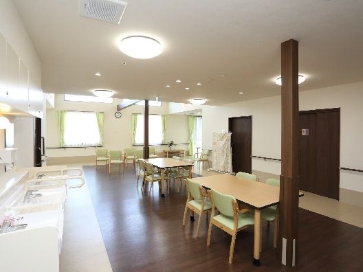 ライトグリーンの椅子がセットされた木製のテーブルセットが複数置かれた食堂には車いす対応の洗面所もある。