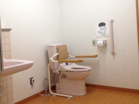 トイレには便座と手洗い器が設置されており、広いスペースが確保されている。手すりは便座の両サイドや壁に付いており、ナースコールもある。