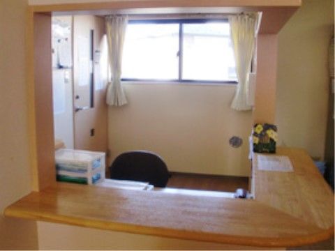 スタッフルームには大きな窓口を設け、24時間体制で常に入居者様の見守りを行っている。カウンター傍の内側にデスクと椅子を備えている。