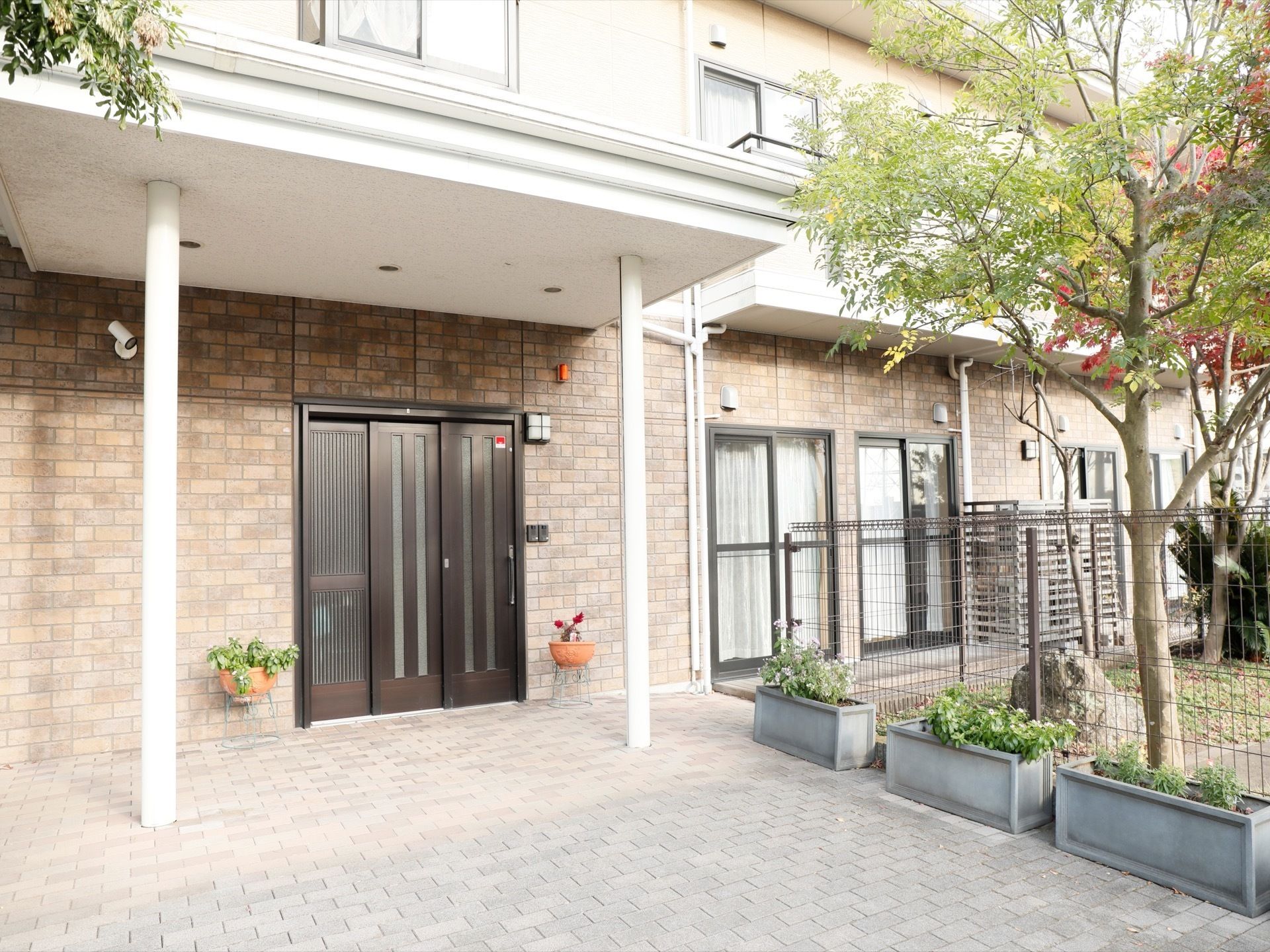 １階の外壁はレンガ調タイルが施されている。玄関の上には、屋根がある。玄関前の床は、バリアフリーで、滑り止めも考慮されている。