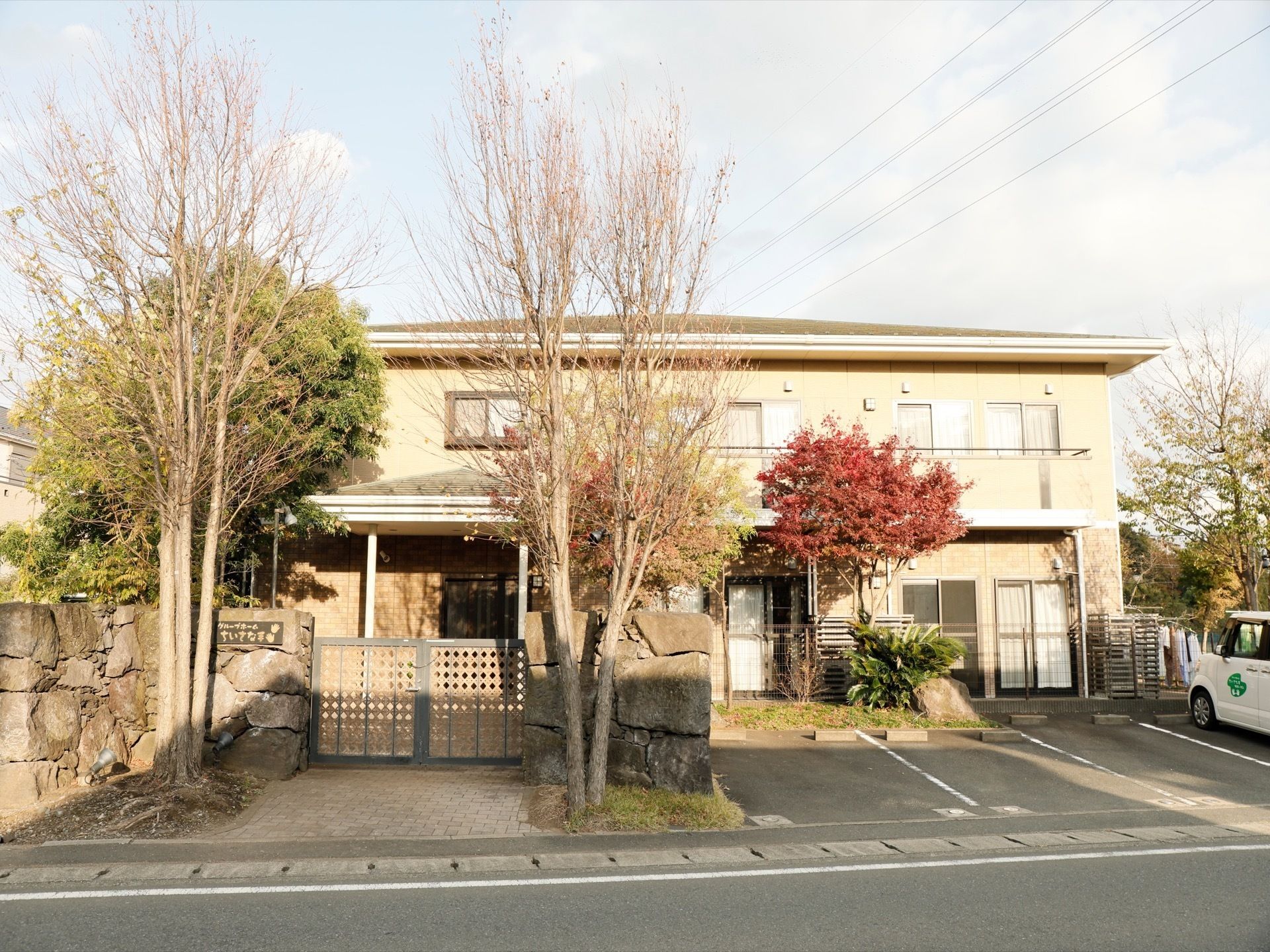 薄茶系の２階建ての建物である。正面には専用の駐車場がある。施設の回りには、大きな樹木が植えられている。