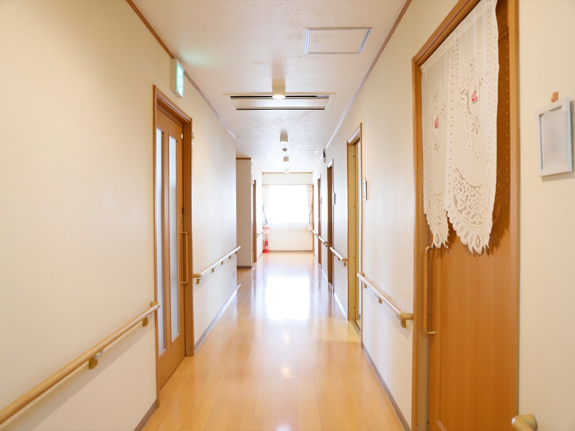 フローリングの明るい廊下には、壁に手すりが取り付けられている。左右に並ぶ部屋の入口は、出入りがしやすい引き戸になっている。