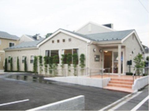 建物前に駐車場、エントランスに手すり付きのスロープと階段が設けられている施設